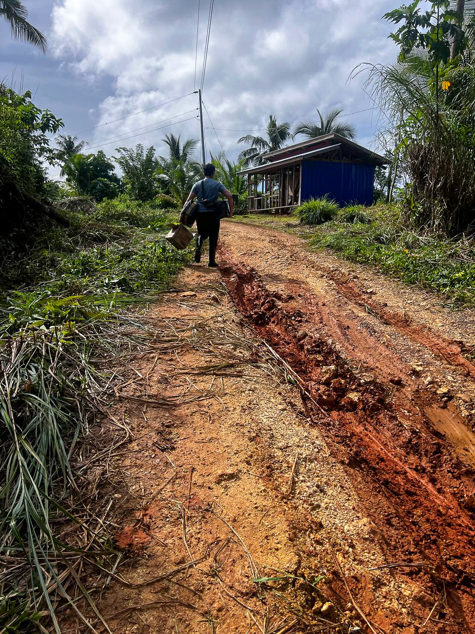 Lindy climbing the muddy road back to our house in Barangay Garcia Siargao Island